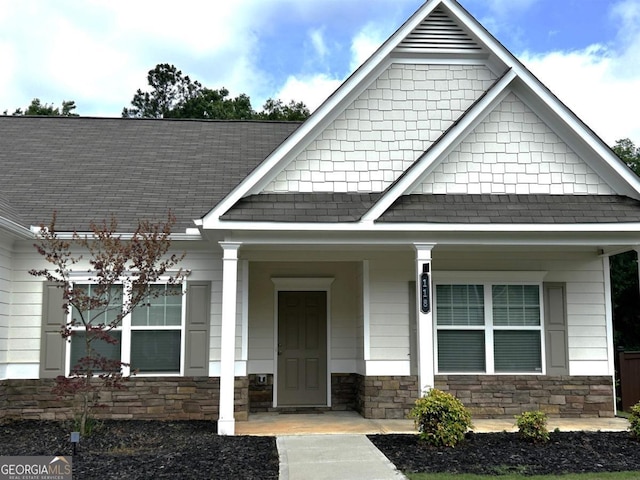 118 Garrett Dr, Eatonton, GA 31024 - craftsman-style home featuring roof with shingles, stone siding, and a porch