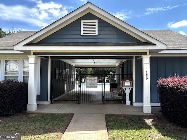 118 Garrett Dr, Eatonton, GA 31024 - view of exterior entry featuring fence, a shingled roof, and board and batten siding
