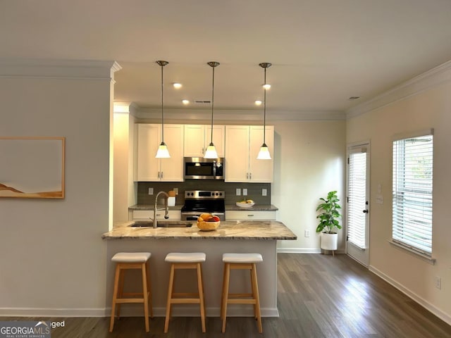 118 Garrett Dr, Eatonton, GA 31024 - kitchen with appliances with stainless steel finishes, a sink, ornamental molding, tasteful backsplash, and white cabinetry