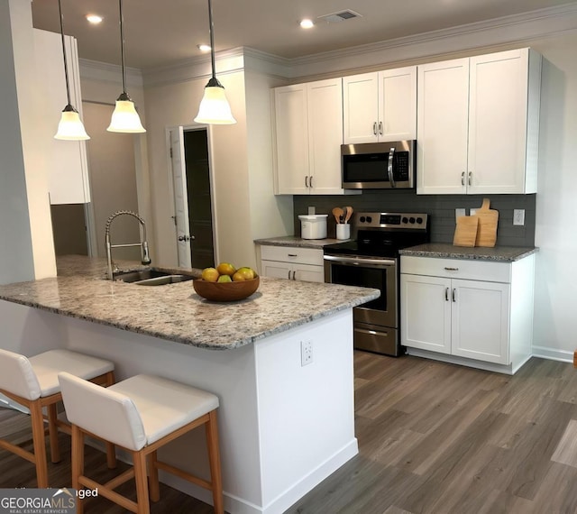 118 Garrett Dr, Eatonton, GA 31024 - kitchen with stainless steel appliances, a sink, backsplash, a breakfast bar area, and white cabinetry