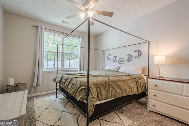 bedroom featuring light carpet, a textured ceiling, ceiling fan, and baseboards