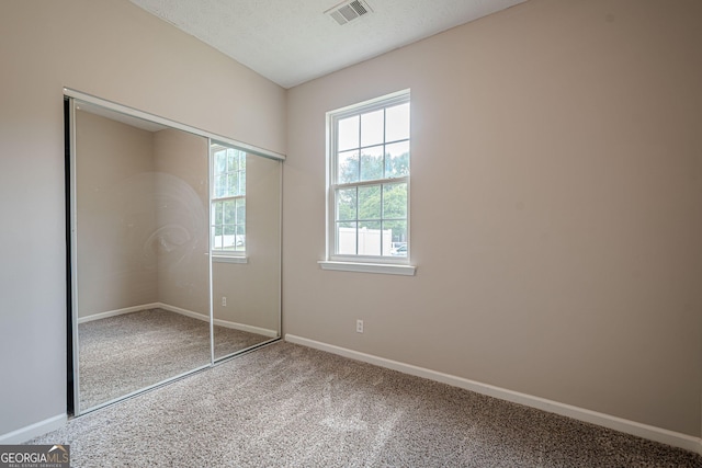 unfurnished bedroom featuring carpet floors, baseboards, and a closet