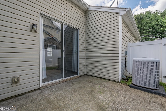 property entrance with central AC unit and a patio