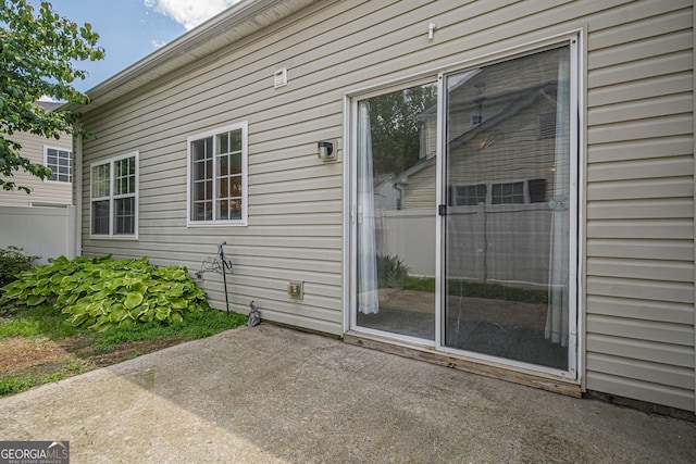 view of exterior entry with a patio