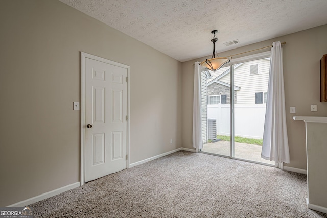 carpeted empty room featuring plenty of natural light, a textured ceiling, and baseboards