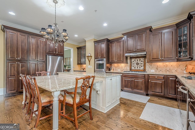 2295 Falmouth Ct SE Unit 23, Smyrna, GA 30080 - kitchen featuring stainless steel appliances, a chandelier, recessed lighting, light wood-style floors, and an island with sink