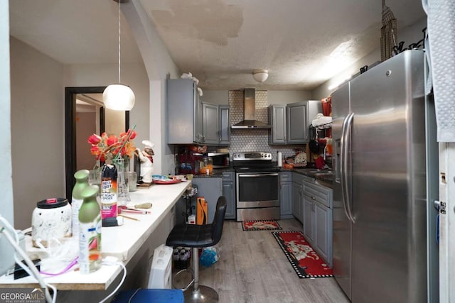 377 Black Oak Ct, Lawrenceville, GA 30046 - kitchen with appliances with stainless steel finishes, wall chimney range hood, gray cabinetry, light wood-style flooring, and tasteful backsplash