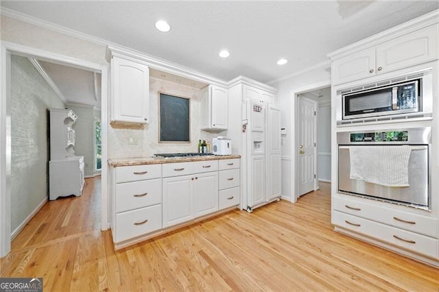 1763 Benningfield Dr SW, Marietta, GA 30064 - kitchen with stainless steel appliances, ornamental molding, white cabinets, light wood-type flooring, and light countertops