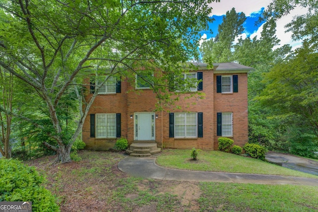view of front of home with brick siding and a front yard