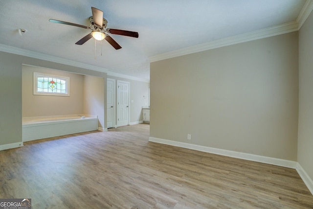 spare room featuring crown molding, light wood-style floors, baseboards, and a ceiling fan