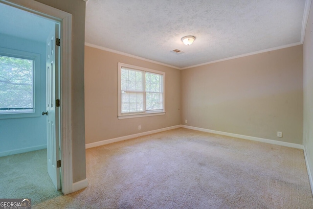 empty room featuring ornamental molding, carpet flooring, baseboards, and a textured ceiling