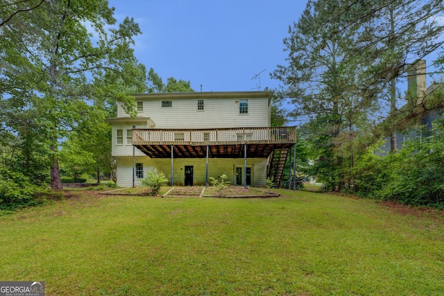 back of property featuring a deck, stairway, and a yard
