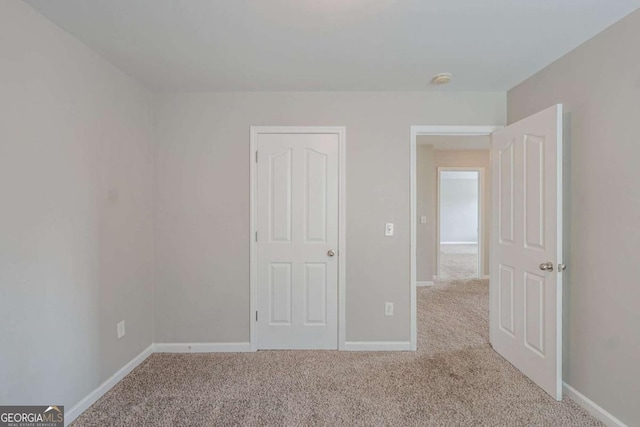 unfurnished bedroom with carpet flooring and baseboards