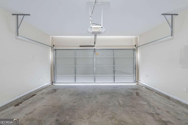 garage featuring a garage door opener and baseboards