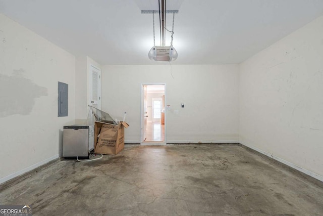 garage with electric panel, a garage door opener, and baseboards
