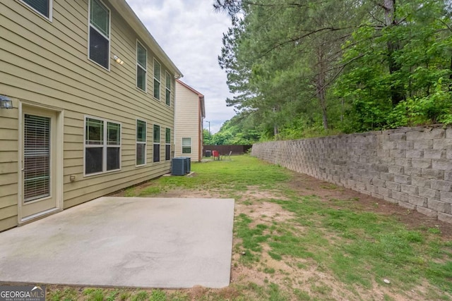 view of yard featuring fence, a patio, and central AC