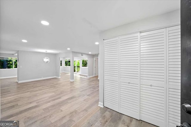 unfurnished living room featuring recessed lighting, plenty of natural light, baseboards, and light wood-style flooring