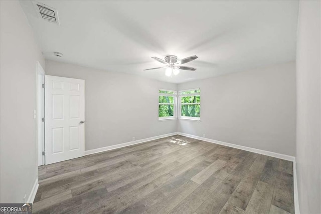 spare room with ceiling fan, wood finished floors, baseboards, and a smoke detector