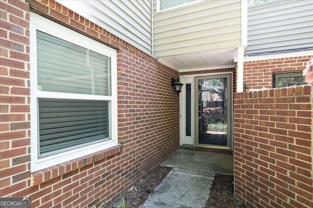 view of exterior entry featuring brick siding