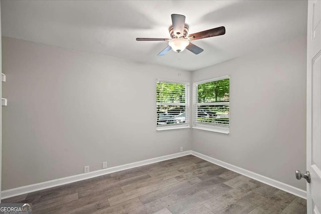 unfurnished room with a ceiling fan, wood finished floors, and baseboards
