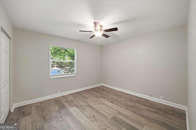 unfurnished bedroom with wood finished floors, a closet, baseboards, and ceiling fan