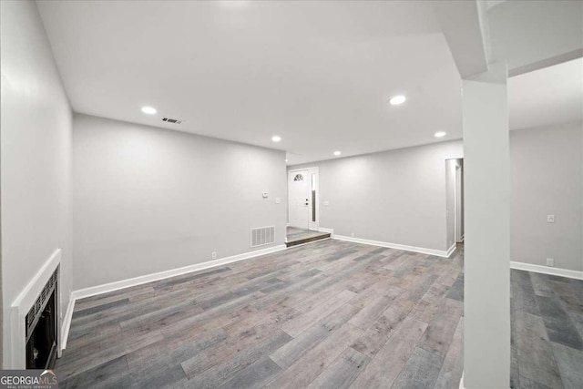 basement with recessed lighting, wood finished floors, and baseboards