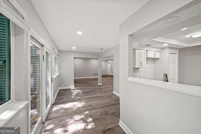 hall featuring wood finished floors, baseboards, and recessed lighting