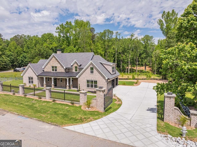 140 Maranatha Trl, Lawrenceville, GA 30045 - view of front of house featuring concrete driveway, covered porch, an attached garage, a standing seam roof, and brick siding