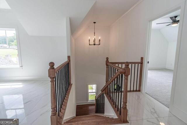 140 Maranatha Trl, Lawrenceville, GA 30045 - staircase featuring marble look tiles, lofted ceiling, plenty of natural light, a chandelier, and baseboards