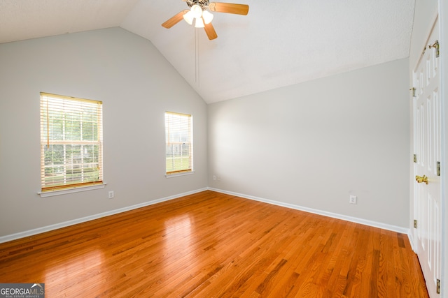 spare room with vaulted ceiling, ceiling fan, light wood-style flooring, and baseboards