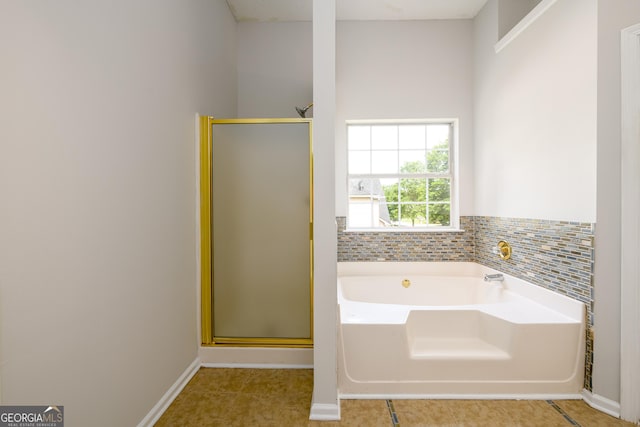 bathroom featuring a shower stall, a garden tub, tile patterned flooring, and baseboards
