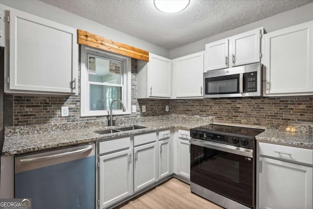 191 Nectar Pl, Dallas, GA 30132 - kitchen featuring stainless steel appliances, a sink, a textured ceiling, light wood-type flooring, and light stone counters