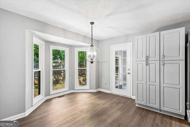 191 Nectar Pl, Dallas, GA 30132 - unfurnished dining area featuring a chandelier, plenty of natural light, dark wood finished floors, baseboards, and a textured ceiling