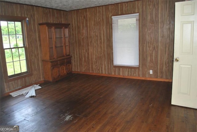 701 Fletcher St, Cedartown, GA 30125 - spare room featuring wood walls, dark wood-style flooring, and baseboards