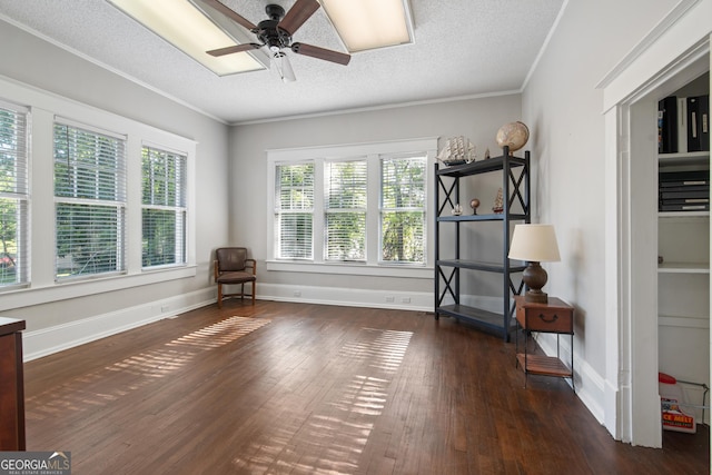 unfurnished room featuring a ceiling fan, wood finished floors, ornamental molding, a textured ceiling, and baseboards