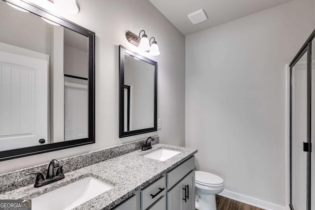 0 Grogan Rd, Buchanan, GA 30113 - full bathroom featuring double vanity, toilet, wood finished floors, baseboards, and a shower