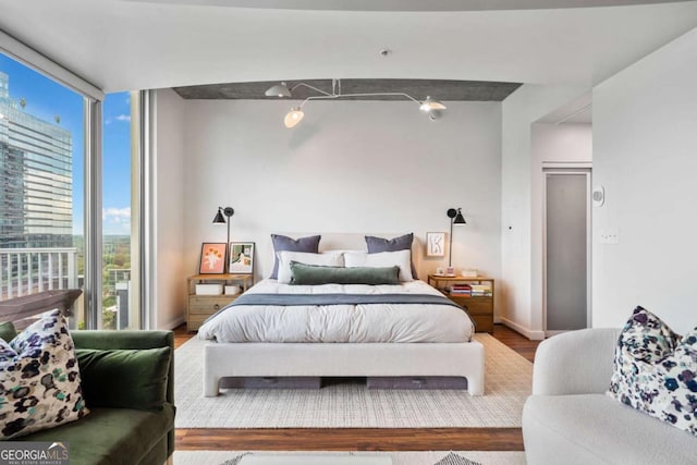 860 Peachtree St NE Unit 1513, Atlanta, GA 30308 - bedroom featuring wood finished floors, floor to ceiling windows, and baseboards