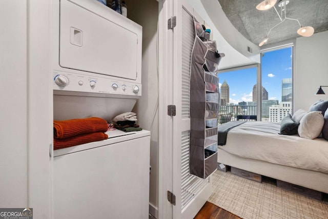 860 Peachtree St NE Unit 1513, Atlanta, GA 30308 - bedroom with estacked washer and dryer, wood finished floors, a view of skyline, and access to exterior