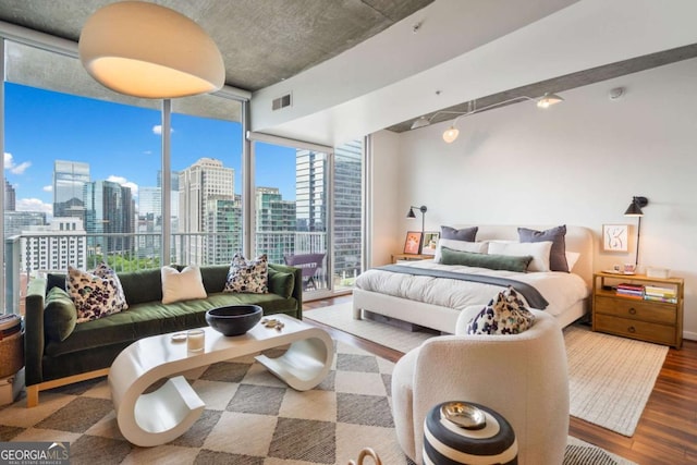 860 Peachtree St NE Unit 1513, Atlanta, GA 30308 - bedroom with a skyline view, wood finished floors, track lighting, and expansive windows