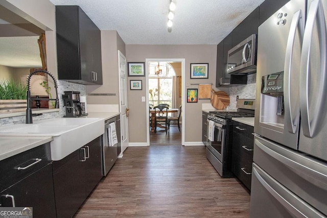 11 Line Creek Cir, Sharpsburg, GA 30277 - kitchen featuring appliances with stainless steel finishes, dark cabinets, a sink, dark wood-type flooring, and decorative backsplash