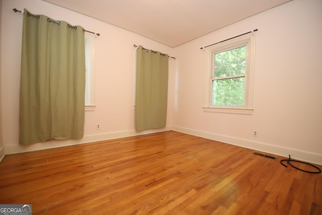spare room featuring light wood finished floors and baseboards