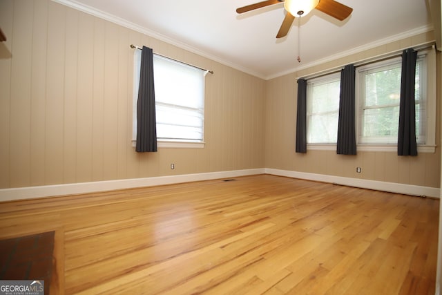 unfurnished room with light wood-type flooring, a ceiling fan, ornamental molding, and baseboards