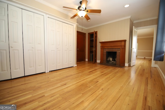 unfurnished living room with crown molding, a ceiling fan, light wood-style flooring, a fireplace, and baseboards