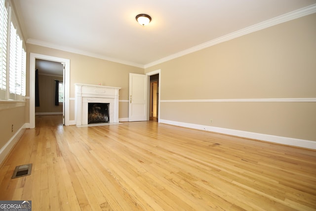 unfurnished living room with light wood finished floors, crown molding, a fireplace with flush hearth, and baseboards