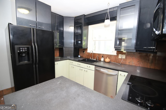 kitchen featuring black appliances, a sink, tasteful backsplash, and glass insert cabinets