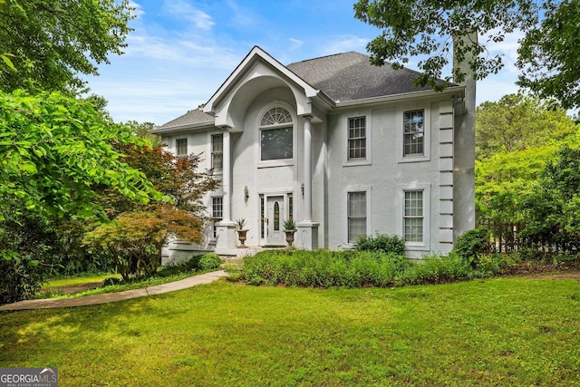 2810 Jodeco Ter, Jonesboro, GA 30236 - view of front of house with a chimney, stucco siding, a front lawn, and roof with shingles