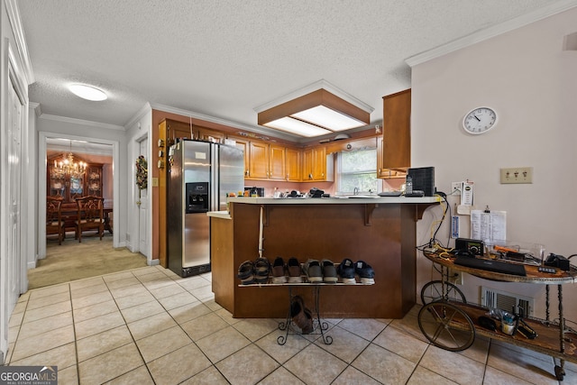 2810 Jodeco Ter, Jonesboro, GA 30236 - kitchen with stainless steel refrigerator with ice dispenser, a chandelier, brown cabinetry, a peninsula, and light tile patterned floors