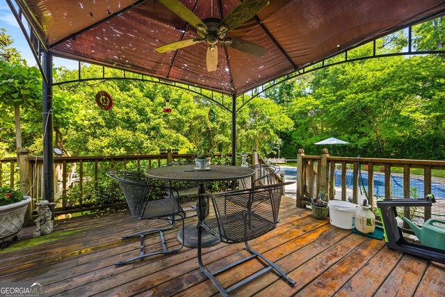 2810 Jodeco Ter, Jonesboro, GA 30236 - wooden deck with ceiling fan, outdoor dining space, and a water view