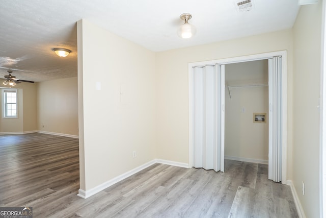 empty room with wood finished floors, baseboards, and ceiling fan