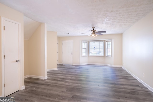 unfurnished living room with ceiling fan, dark wood-style floors, and baseboards